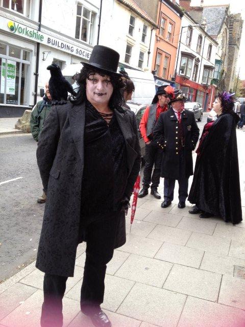 Photo of a Gothic man with a raven on his shoulder